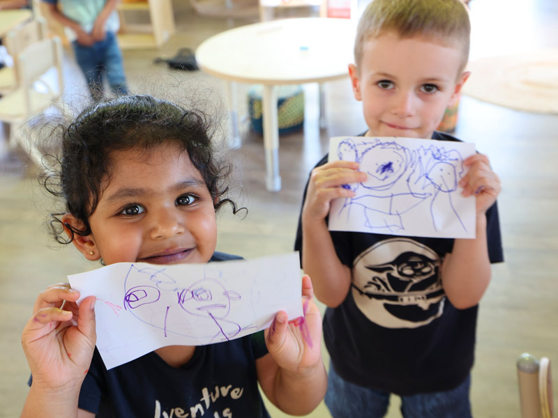 children showing their work at Ambrose Early Learning St Lukes